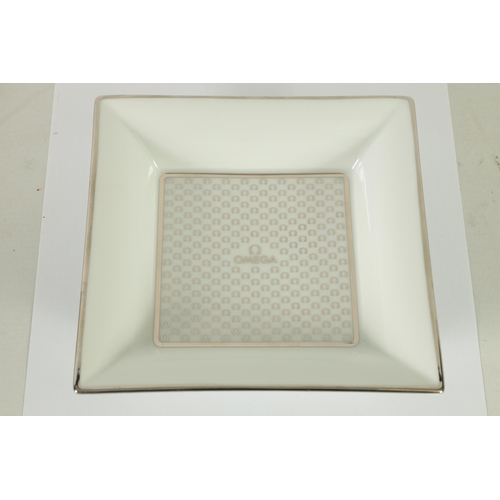 84 - A 1960’S BOXED OMEGA LIMOGES PORCELAIN OMEGA TRINKET DISH of square form with silver motif decoratio... 