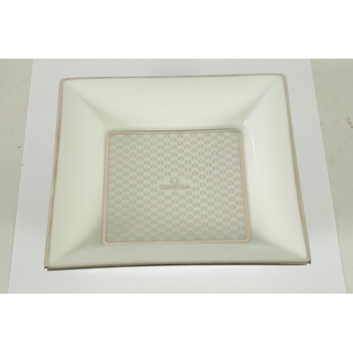 84 - A 1960’S BOXED OMEGA LIMOGES PORCELAIN OMEGA TRINKET DISH of square form with silver motif decoratio... 