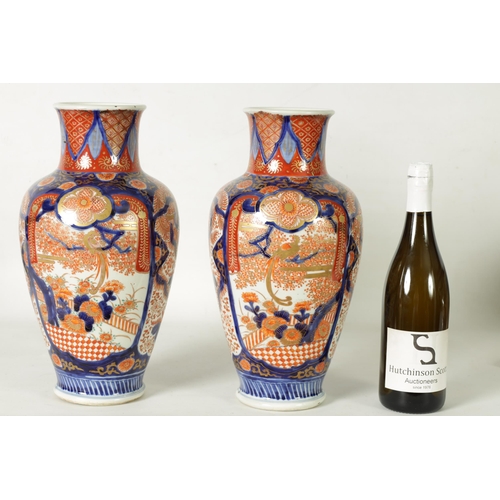 302 - A GOOD LARGE PAIR OF 19TH CENTURY IMARI TAPERING SHOULDERED VASES decorated in the traditional palet... 