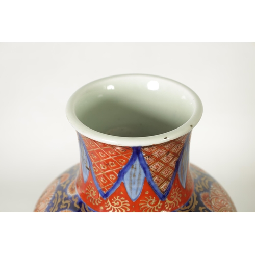 302 - A GOOD LARGE PAIR OF 19TH CENTURY IMARI TAPERING SHOULDERED VASES decorated in the traditional palet... 
