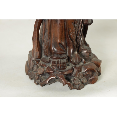 322 - A LATE 19TH CENTURY CHINESE CARVED HARDWOOD FIGURAL SCULPTURE OF AN EMPEROR robed holding a staff. (... 