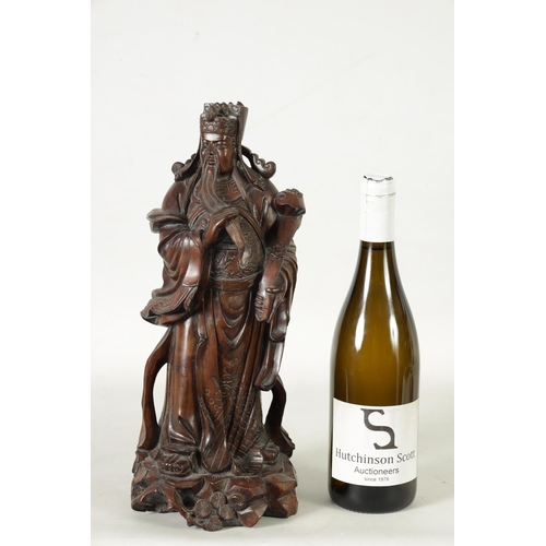 322 - A LATE 19TH CENTURY CHINESE CARVED HARDWOOD FIGURAL SCULPTURE OF AN EMPEROR robed holding a staff. (... 