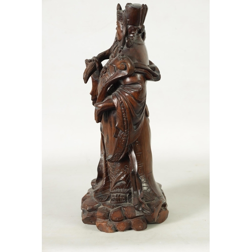 322 - A LATE 19TH CENTURY CHINESE CARVED HARDWOOD FIGURAL SCULPTURE OF AN EMPEROR robed holding a staff. (... 
