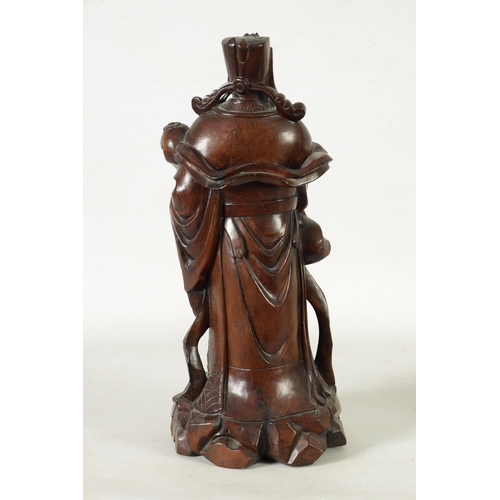 322 - A LATE 19TH CENTURY CHINESE CARVED HARDWOOD FIGURAL SCULPTURE OF AN EMPEROR robed holding a staff. (... 