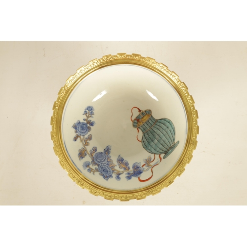 336 - AN ORMOLU MOUNTED CHINESE BOWL pale blue ground with floral decoration enclosing foo dog panels, the... 