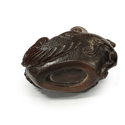 352 - A CHINESE CARVED RHINOCEROS HORN SNUFF BOTTLE modelled as an exotic bird with pierced tail feathers.