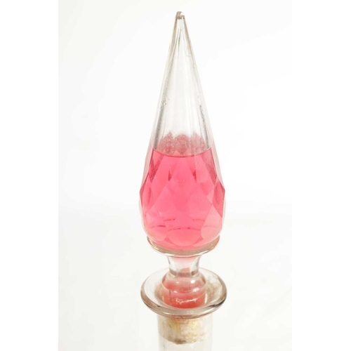 10 - A LARGE LATE 19TH CENTURY CLEAR GLASS PHARMACY BOTTLE with facetted stopper and bulbous body; filled... 