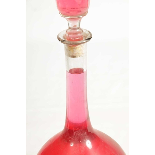 10 - A LARGE LATE 19TH CENTURY CLEAR GLASS PHARMACY BOTTLE with facetted stopper and bulbous body; filled... 