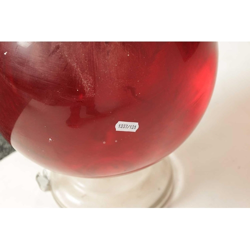 10 - A LARGE LATE 19TH CENTURY CLEAR GLASS PHARMACY BOTTLE with facetted stopper and bulbous body; filled... 