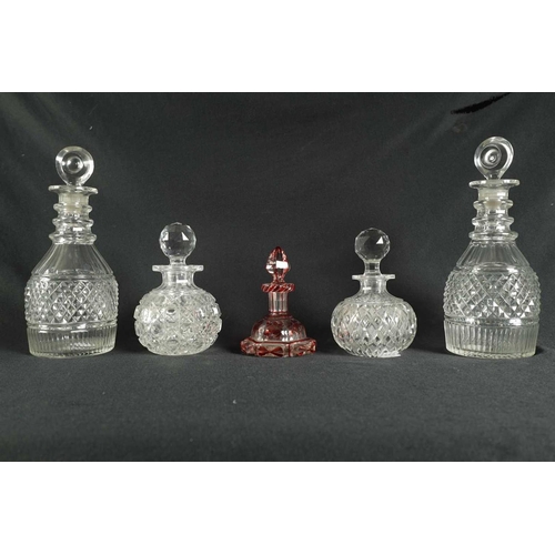 5 - A PAIR OF 19TH CENTURY CUT GLASS DECANTERS with bulls-eye stoppers, triple ringed necks and hobnail-... 