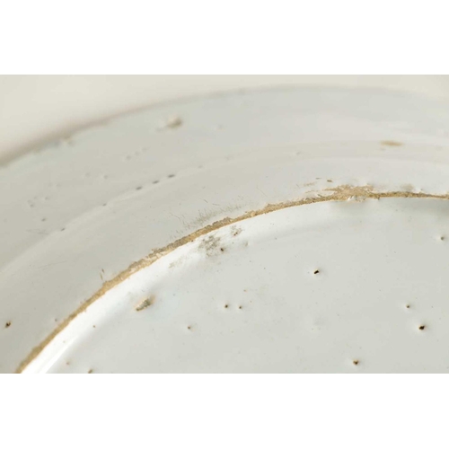 55 - AN 18TH-CENTURY DELFT BLUE AND WHITE PLATE with scrolled spired border enclosing a formal fenced gar... 