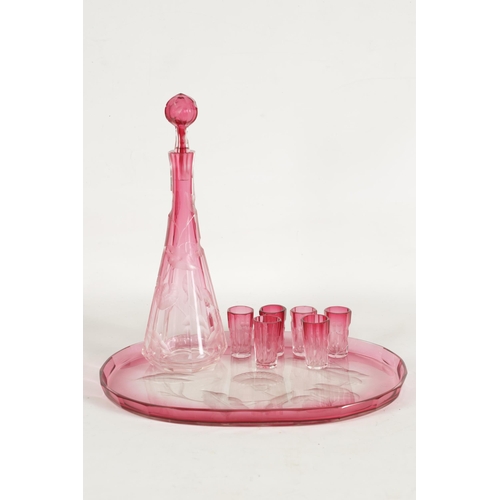 11 - AN ART NOUVEAU RUBY AND CLEAR GLASS MOSER DECANTER, TRAY AND SIX GLASSES deeply cut with intaglio de... 