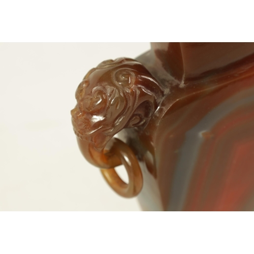 122 - A CHINESE CARVED CARNELIAN AGATE VASE AND COVER the lid carved with foo dog finial on a flattened ta... 