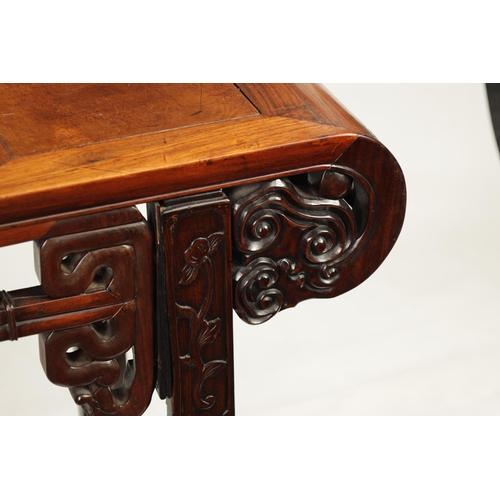 125 - A 19TH CENTURY CHINESE HARDWOOD ALTAR TABLE with panelled top and scrolled carved sides joined by a ... 