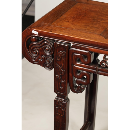 125 - A 19TH CENTURY CHINESE HARDWOOD ALTAR TABLE with panelled top and scrolled carved sides joined by a ... 