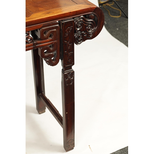 125 - A 19TH CENTURY CHINESE HARDWOOD ALTAR TABLE with panelled top and scrolled carved sides joined by a ... 