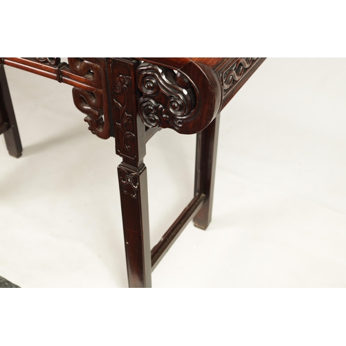 125 - A 19TH CENTURY CHINESE HARDWOOD ALTAR TABLE with panelled top and scrolled carved sides joined by a ... 