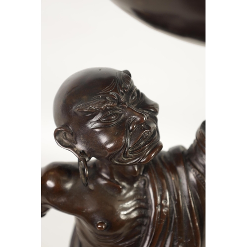 138 - A LARGE 19TH CENTURY CHINESE BRONZE RAKAN FIGURAL TABLE GONG depicted holding a large bowl gong; rai... 