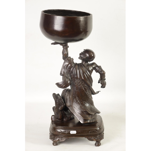 138 - A LARGE 19TH CENTURY CHINESE BRONZE RAKAN FIGURAL TABLE GONG depicted holding a large bowl gong; rai... 