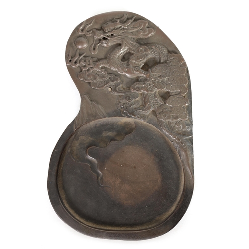 147 - A CHINESE DRAGON INKSTONE of shaped form with relief carved dragon amongst stylised clouds, Chinese ... 