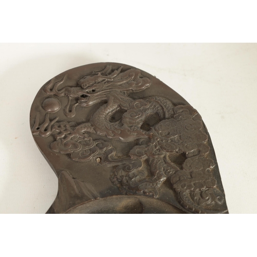 147 - A CHINESE DRAGON INKSTONE of shaped form with relief carved dragon amongst stylised clouds, Chinese ... 