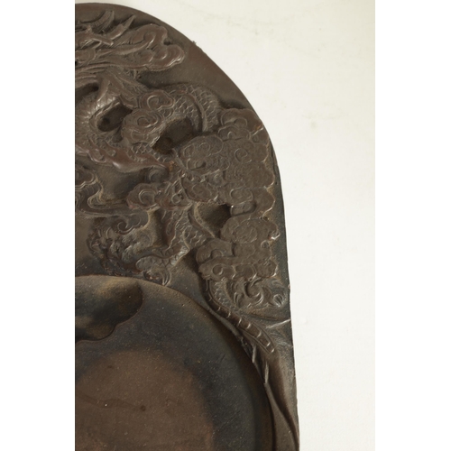 147 - A CHINESE DRAGON INKSTONE of shaped form with relief carved dragon amongst stylised clouds, Chinese ... 