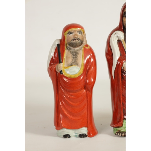 155 - TWO MEIJI PERIOD JAPANESE KUTANI PORCELAIN FIGURES OF DARUMA both dressed in red robes and holding f... 