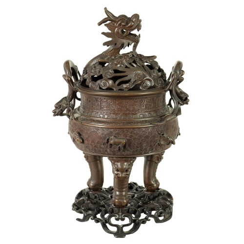 156 - A 19TH CENTURY CHINESE BRONZE CENSER AND LID MOUNTED ON A HARDWOOD STAND with pierced dragons head a... 