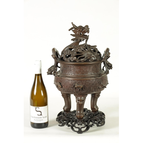 156 - A 19TH CENTURY CHINESE BRONZE CENSER AND LID MOUNTED ON A HARDWOOD STAND with pierced dragons head a... 