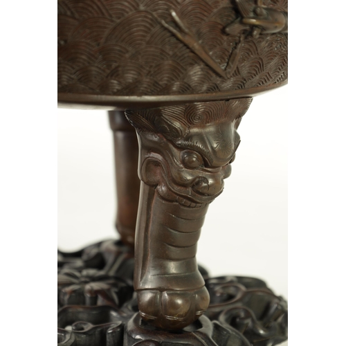 156 - A 19TH CENTURY CHINESE BRONZE CENSER AND LID MOUNTED ON A HARDWOOD STAND with pierced dragons head a... 