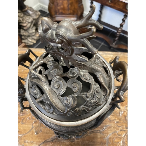 156 - A 19TH CENTURY CHINESE BRONZE CENSER AND LID MOUNTED ON A HARDWOOD STAND with pierced dragons head a... 