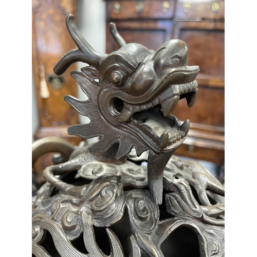 156 - A 19TH CENTURY CHINESE BRONZE CENSER AND LID MOUNTED ON A HARDWOOD STAND with pierced dragons head a... 