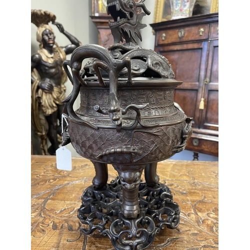 156 - A 19TH CENTURY CHINESE BRONZE CENSER AND LID MOUNTED ON A HARDWOOD STAND with pierced dragons head a... 