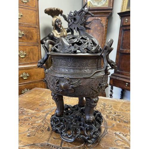 156 - A 19TH CENTURY CHINESE BRONZE CENSER AND LID MOUNTED ON A HARDWOOD STAND with pierced dragons head a... 