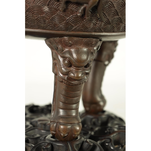 156 - A 19TH CENTURY CHINESE BRONZE CENSER AND LID MOUNTED ON A HARDWOOD STAND with pierced dragons head a... 