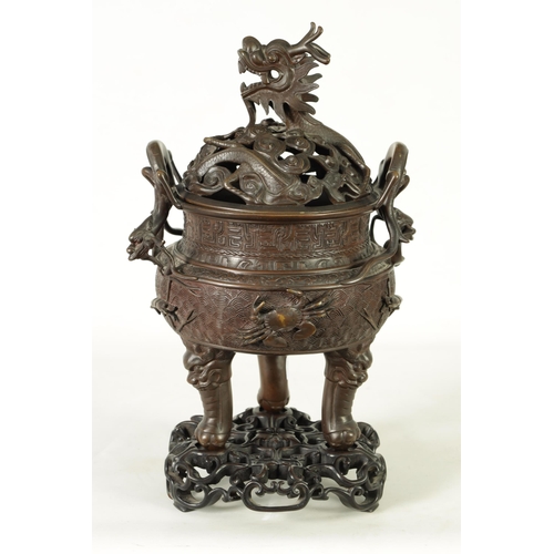 156 - A 19TH CENTURY CHINESE BRONZE CENSER AND LID MOUNTED ON A HARDWOOD STAND with pierced dragons head a... 