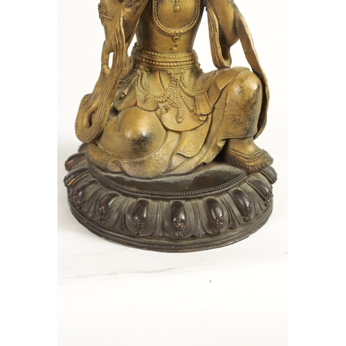 164 - AN EARLY GILT BRONZE TIBETAN BUDDHA highlighted in blue and mounted on a circular bronze moulded bas... 