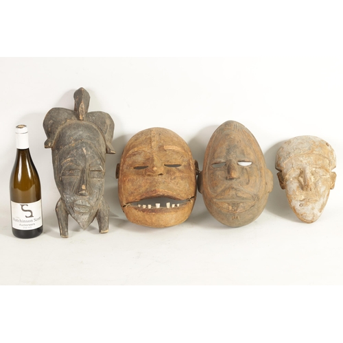 168 - A COLLECTION OF FOUR TRIBAL AFRICAN FACE MASKS one with teeth and moveable jaw. (28cm high and small... 