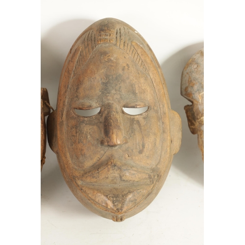 168 - A COLLECTION OF FOUR TRIBAL AFRICAN FACE MASKS one with teeth and moveable jaw. (28cm high and small... 