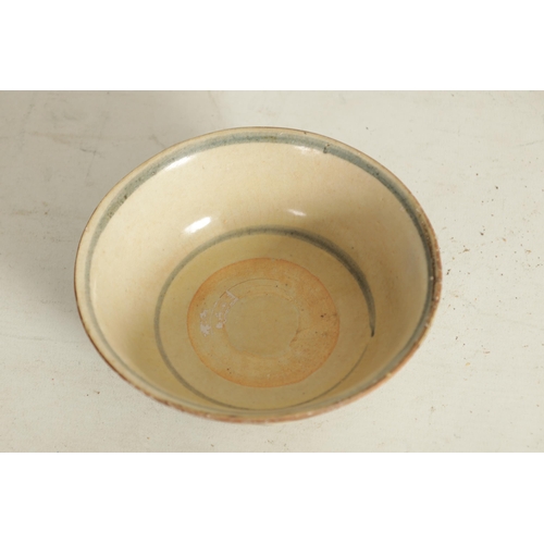 176 - A CHINESE MING SLIPWARE BOWL with blue scrollwork decoration on tapering foot (14.6cm diameter)