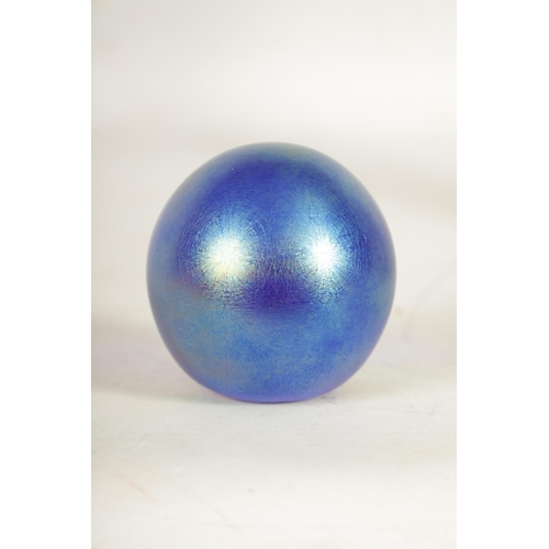 18 - A LOETZ TYPE GLOBULAR PAPERWEIGHT with iridescent finish and cut flat front enclosing a cased flower... 