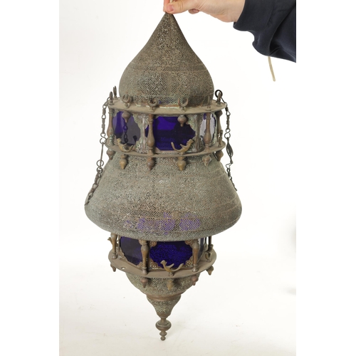 190 - A 19TH CENTURY EASTERN PIERCED BRASS HANGING LANTERN with blue glazed panels and Islamic-style case.... 