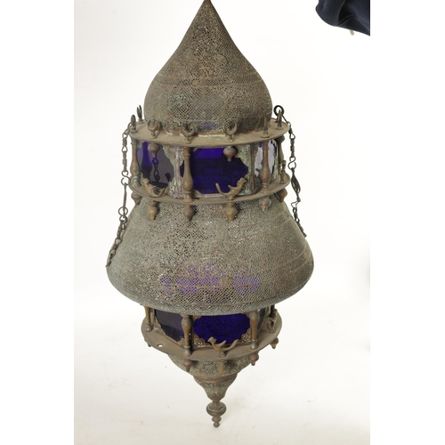 190 - A 19TH CENTURY EASTERN PIERCED BRASS HANGING LANTERN with blue glazed panels and Islamic-style case.... 