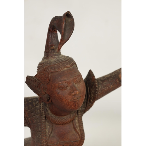 193 - AN EARLY 20TH CENTURY BURMESE CARVED HARDWOOD DANCING FIGURE mouted on a wavy edge base (68cm high )