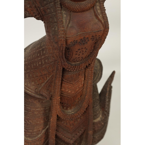 193 - AN EARLY 20TH CENTURY BURMESE CARVED HARDWOOD DANCING FIGURE mouted on a wavy edge base (68cm high )