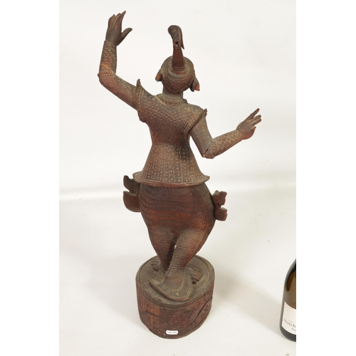 193 - AN EARLY 20TH CENTURY BURMESE CARVED HARDWOOD DANCING FIGURE mouted on a wavy edge base (68cm high )