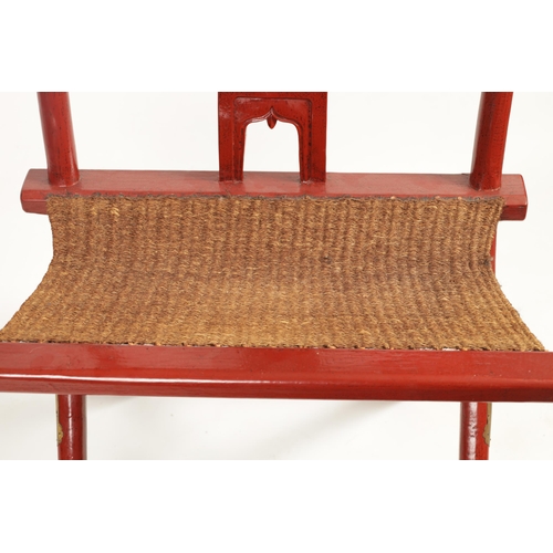 200 - A LATE 19TH CENTURY CHINESE RED LACQUERWORK X-FRAMED FOLDING CHAIR the shaped open back with medalli... 