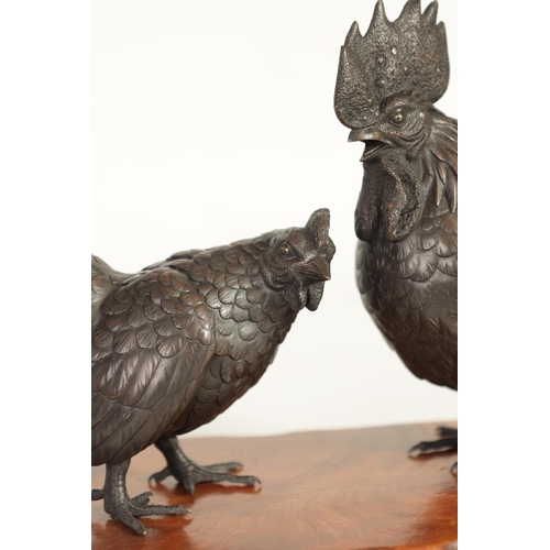 209 - A JAPANESE MEIJI PATINATED BRONZE SCULPTURE ON HARDWOOD BASE finely modelled as a cockerel and hen s... 