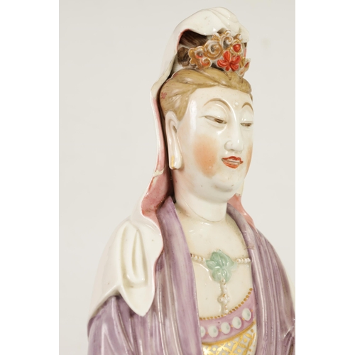 215 - A 19TH CENTURY CHINESE PORCELAIN GUAN YIN STATUE decorated with polychrome colours, on a naturalisti... 