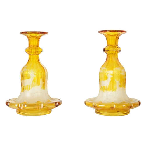 23 - A FINE PAIR OF 19TH CENTURY BOHEMIAN AMBER FLASHED GLASS DECANTERS decorated with Stags amongst wood... 